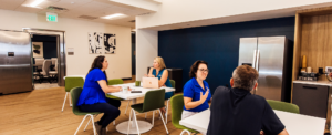Professionals sitting and talking around tables in a coworking area